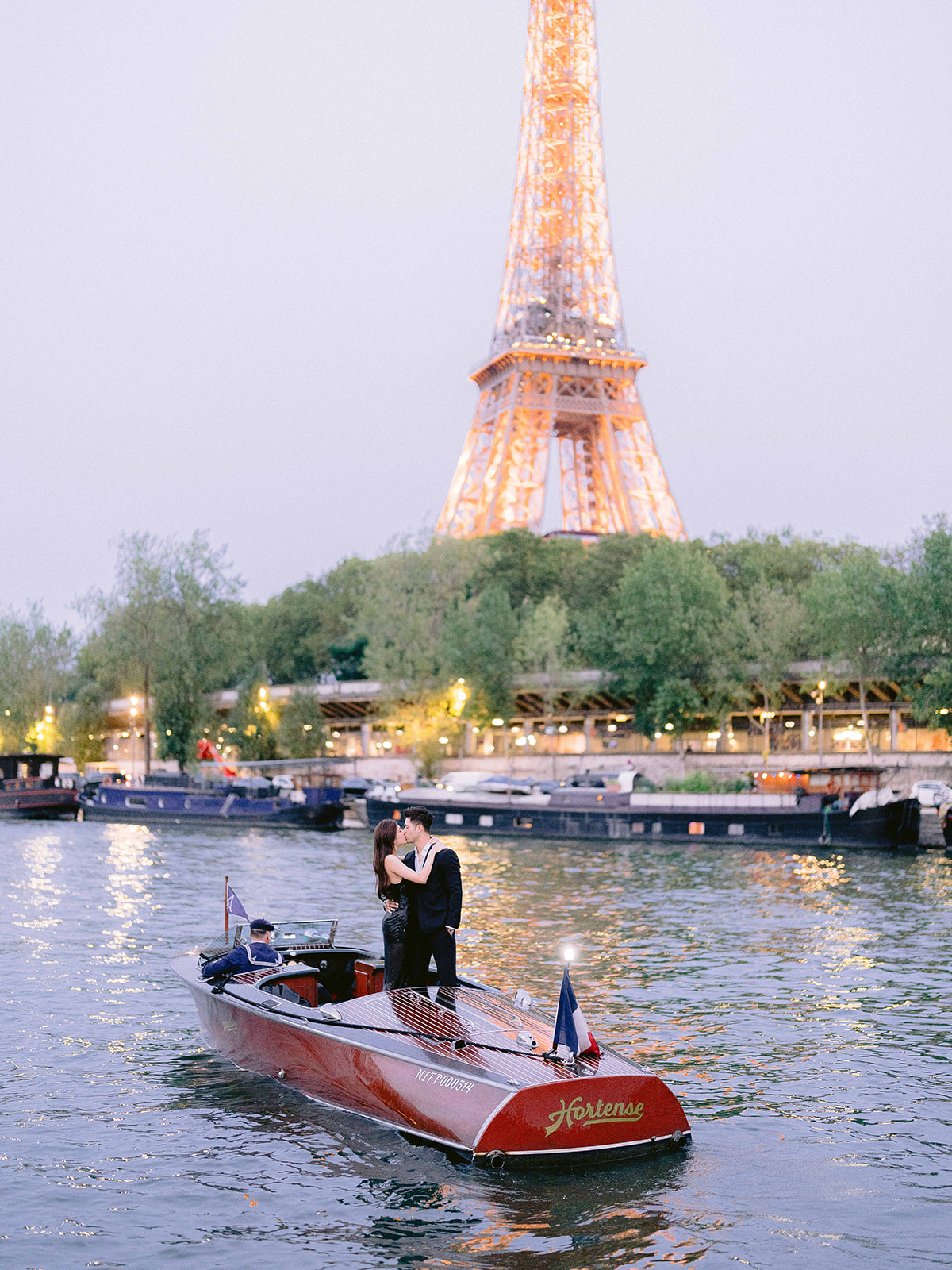Paris engagement couple kissing on a private boat with the Eiffel Tower at sunset